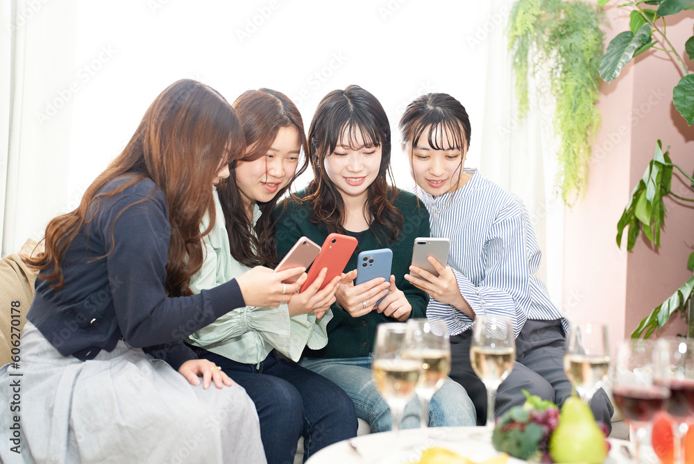 Obraz premium スマホを見ながら会話する女性4人