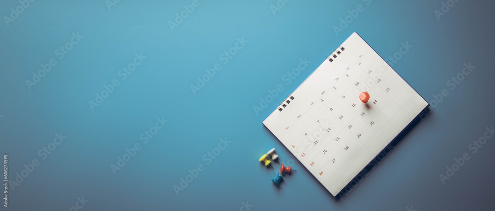 Closeup calendar page with drawing-pins , planning for business meeting or travel planning concept Closeup calendar page with drawing-pins , planning for business meeting or travel planning concept