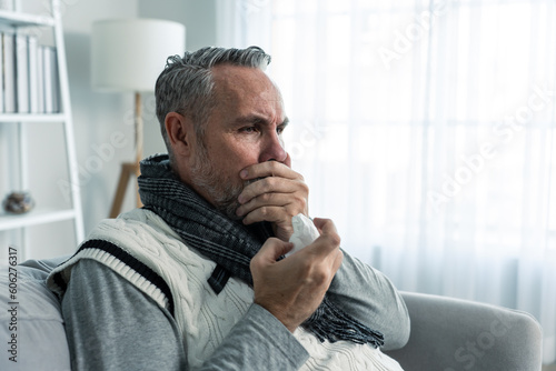 Photos Caucasian senior man having running nose and sneezing in living room