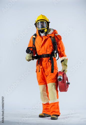 Professional firefighter standing confidently on white background while holding a fire hose.
