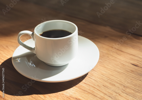 cup of coffee on a wooden table with natural sunlight
