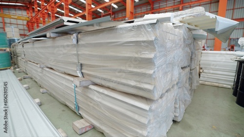 Close up stack of roofing sheets in metal sheet factory. Metal sheet roof silver colour at warehouse metal roofing factory. Metal sheet roof equipment