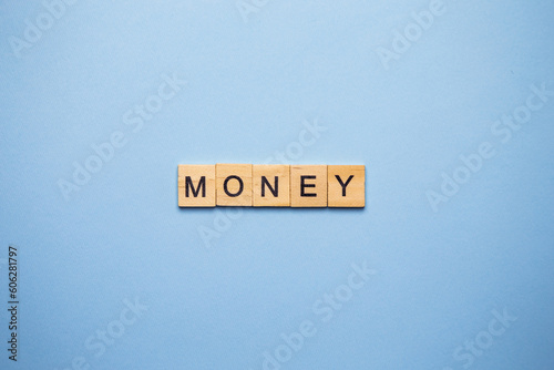 Finance concept. On a blue surface, wooden cubes with the inscription money. photo