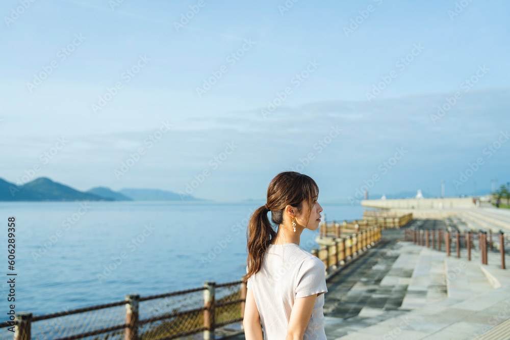 夕暮れの海にいる女性