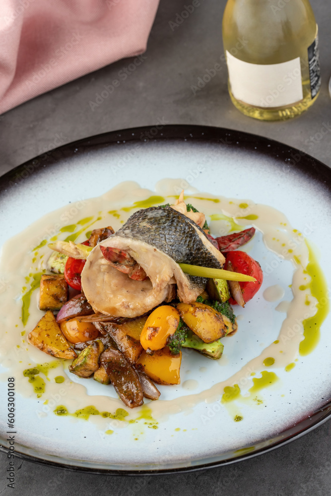 Shrimp wrapped in sea bass on various vegetables on a porcelain plate Shrimp wrapped in sea bass on various vegetables on a porcelain plate