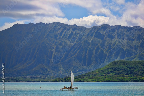 Outrigger canoe sailing in Kaneohe Bay with the Ko'olau mountains the background on the island of Oahu, Hawaii photo
