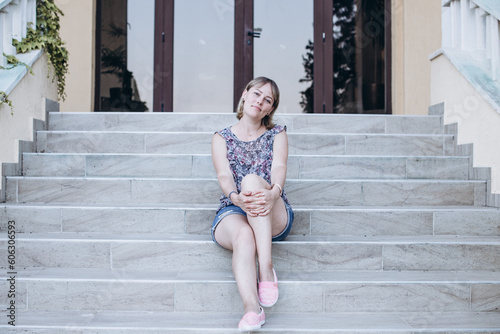 Young beautiful girl posing for foto on the stairs in summer © Svetlana