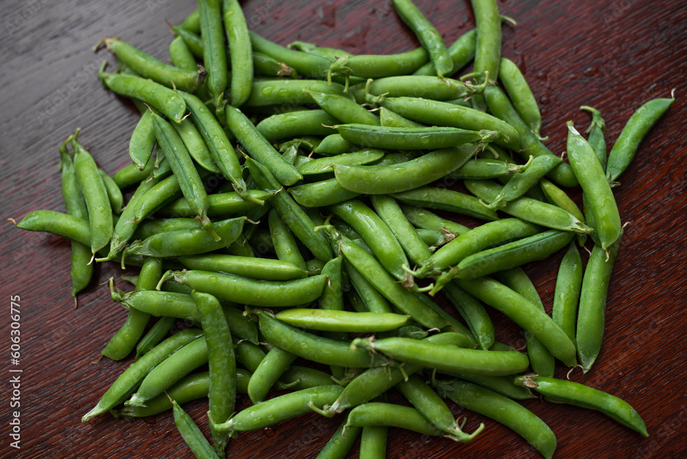 Pods of fresh, washed green peas lie on the table. Pods of fresh, washed green peas lie on the table.