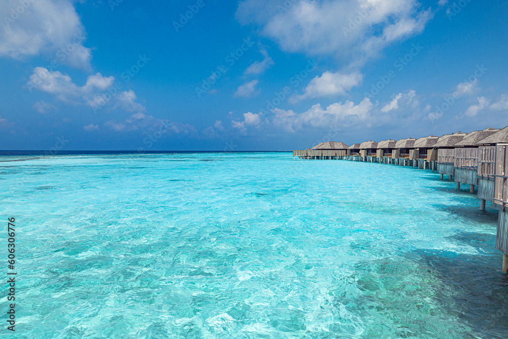Panoramic landscape of Maldives beach. Exotic vacation seascape water villas bungalows resort with wooden pier bridge. Luxury travel destination. Fantastic turquoise blue ocean lagoon bay sunny sky