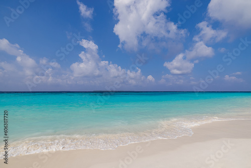Sunny closeup of sea sand beach blue summer sky. Panoramic beach landscape. Tranquil relaxing sunshine soft waves splashing on Mediterranean sandy shore. Coastline seaside idyllic nature background