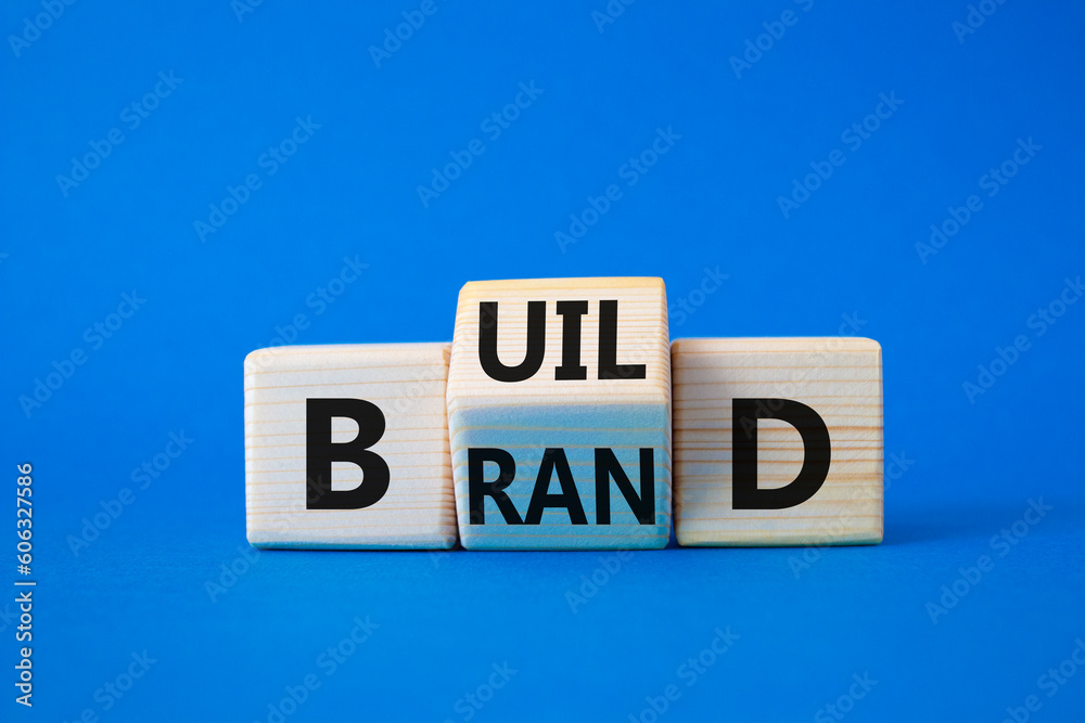 Build your brand symbol. Wooden cubes with words Build and Brand. Beautiful blue background. Build your brand and business concept. Copy space Build your brand symbol. Wooden cubes with words Build and Brand. Beautiful blue background. Build your brand and business concept. Copy space