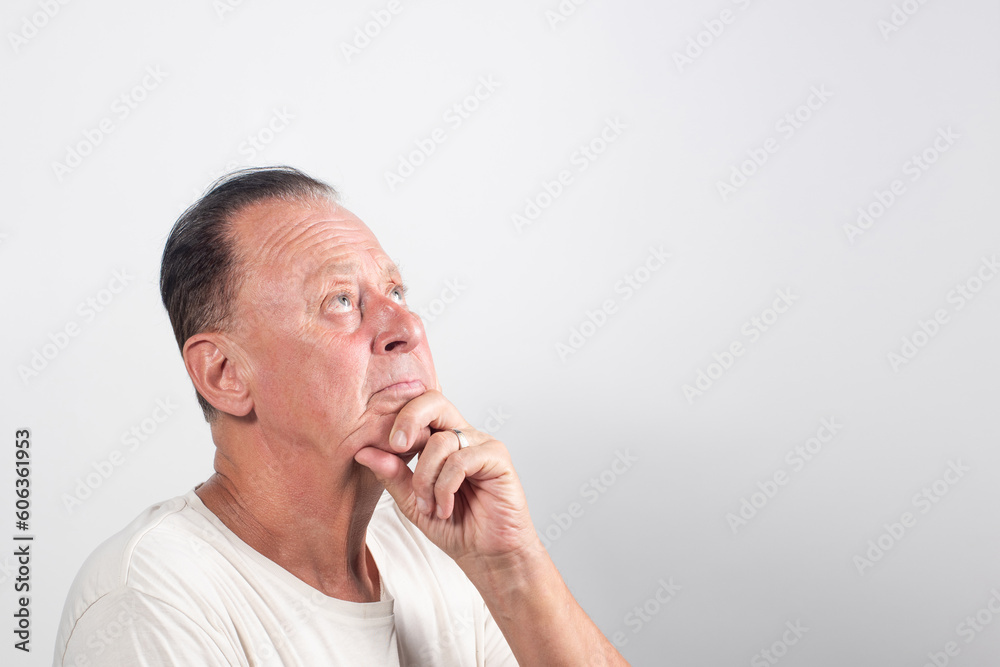 Serious middle-aged man with white shirt having doubts and with confuse face expression on isolated white background Serious middle-aged man with white shirt having doubts and with confuse face expression on isolated white background