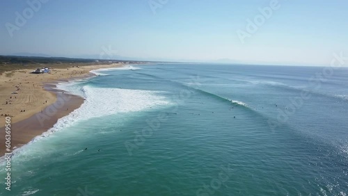 Aerial drone cinematic surfers paddling out to surf wave swell Hoosegor Capbreton France Europe Bay of Biscay WSL Quiksilver Pro central beach Peronze sunny mid day slowly circling left movement photo