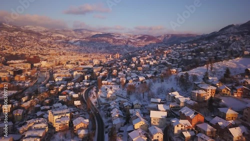 Aerial cinematic drone snowy roads winter Olympic downtown snowy frozen Sarajevo City town center Bosnia and Herzegovina frozen landscape afternoon sunset golden purple backward movement photo