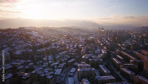 Aerial cinematic drone snowy roads winter Olympic downtown snowy frozen Sarajevo City town center Bosnia and Herzegovina landscape afternoon sunset golden purple circle right movement photo