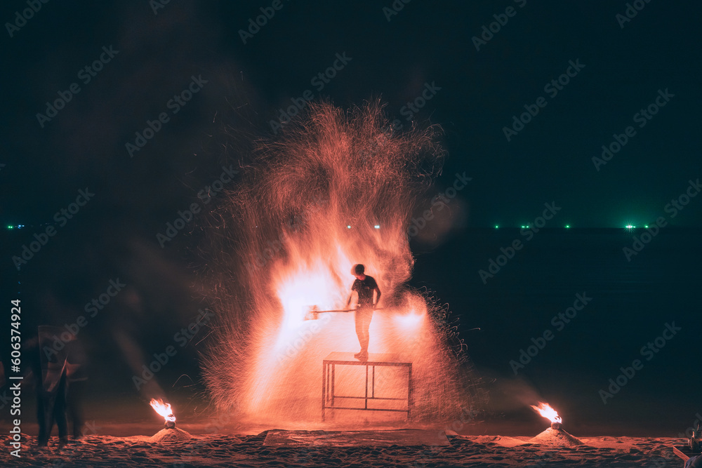 Fire steel wool with water reflection on sea in beach club party at night Samui Thailand