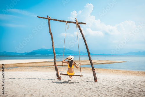 Traveler asian woman relax and travel in swing on summer beach at Koh Rap Samui in Surat Thani Thailand photo