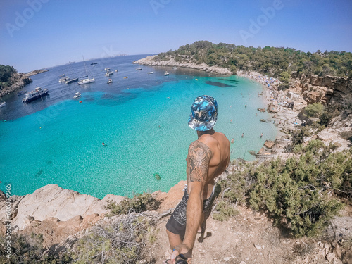 Selfie a cala salada Ibiza, laguna cristallina con barche e spiaggia photo