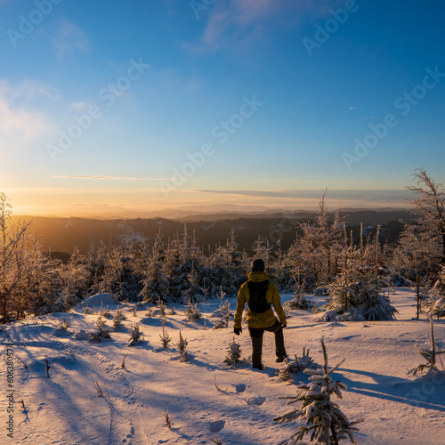 Beautiful amazing sunset winter mountains. A man goes a sport hike in snow holidays. Christmas background. Unique landscape. Mt lysa, beskydy mountains in czech