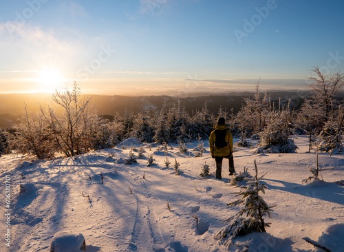 Beautiful amazing sunset winter mountains. A man goes a sport hike in snow holidays. Christmas background. Unique landscape. Mt lysa, beskydy mountains in czech #606380701