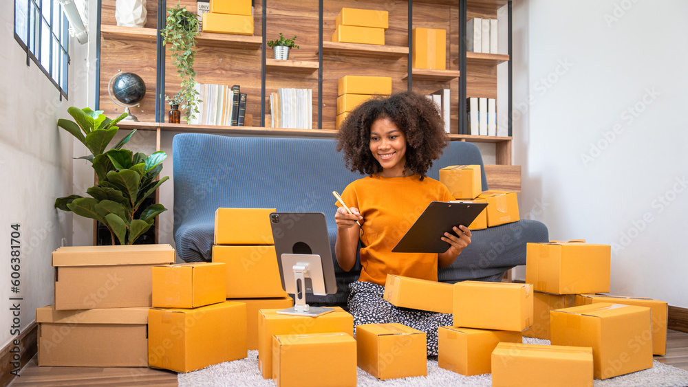 African American business woman working at warehouse preparing SME package box for delivery at small business home office. African American business woman working at warehouse preparing SME package box for delivery at small business home office.