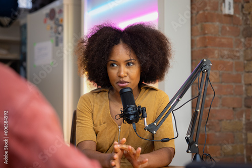 Female podcaster interviewing a guest in a recording studio