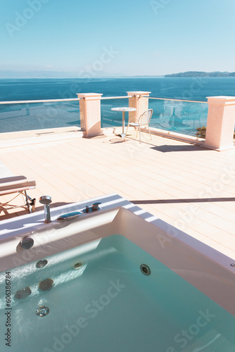 Terrace with sun loungers  outdoor hot tub and sea views. Relaxed holidays in a Mediterranean resort in Greece