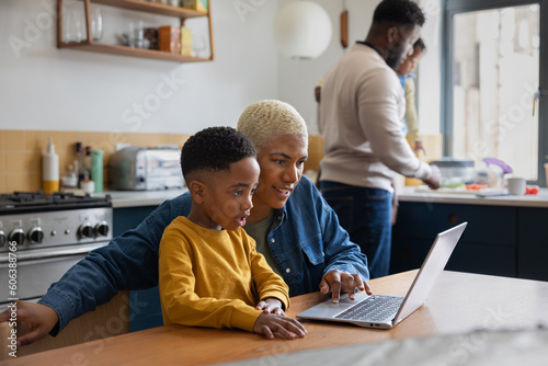 Mom showing son how to use a laptop photo