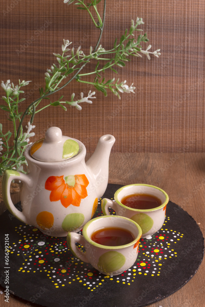 Indian masala chai or tea in cup, with kettle, spices and tea leaves on dark, wooden background. cafe, retro, restaurant, vintage, ethnic, healthy, hotel concepts.
