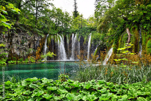 Scenic view of Plitvice lakes with waterfalls surrounded by dense green trees in Croatia