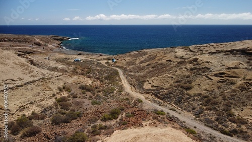 Drone shot of path in volcanic desert in Tenerife, running towards beach and sea © Ben Owen/Wirestock Creators