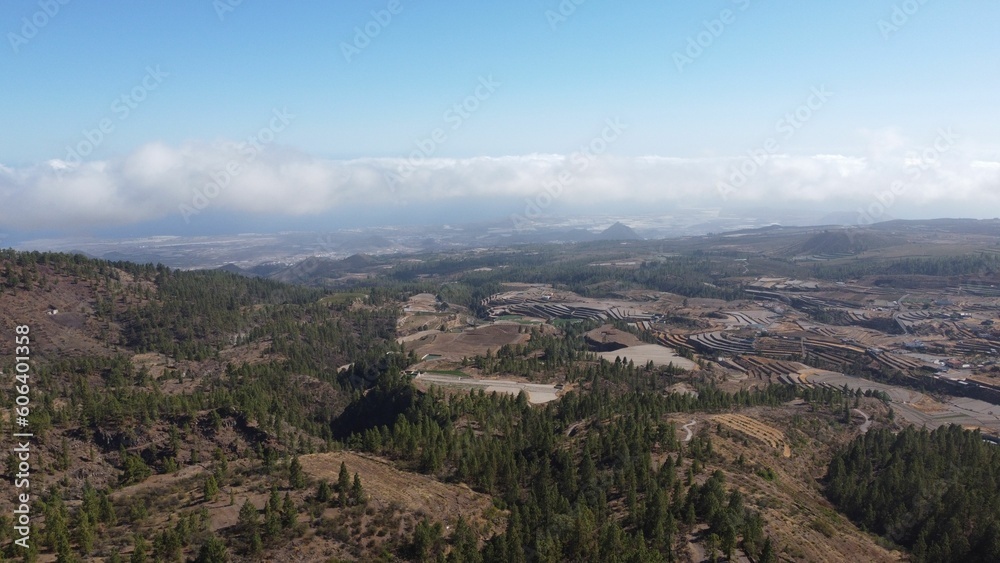 High-altitude farmland in Tenerife from above clouds, looking down towards the coast, aerial High-altitude farmland in Tenerife from above clouds, looking down towards the coast, aerial