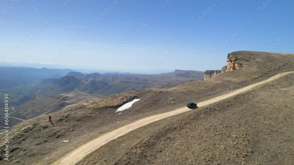 Aerial view of a car driving on a mountain road. Landscape and nature of the North Caucasus Aerial view of a car driving on a mountain road. Landscape and nature of the North Caucasus