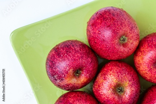 Top view of red apples of pero bravo esmolfe species washed with fresh water on a green plate photo