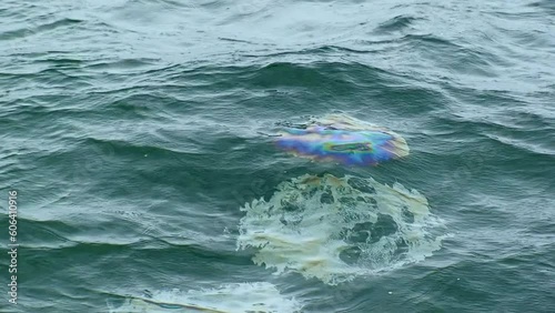 Oil pollution of the sea -a series of oil slicks on the stormy sea surface, which emerge from the depths of the sea. Shipwreck, failure, war, pipeline. Black Sea, Ukraine. photo