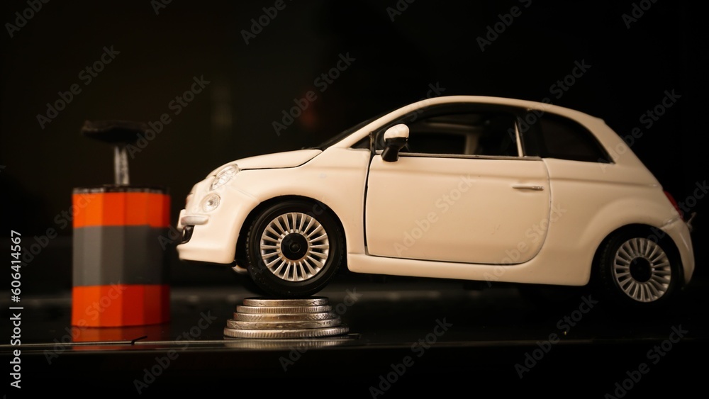 Fototapeta premium Car expenses concept with miniature toy car on stack of coins