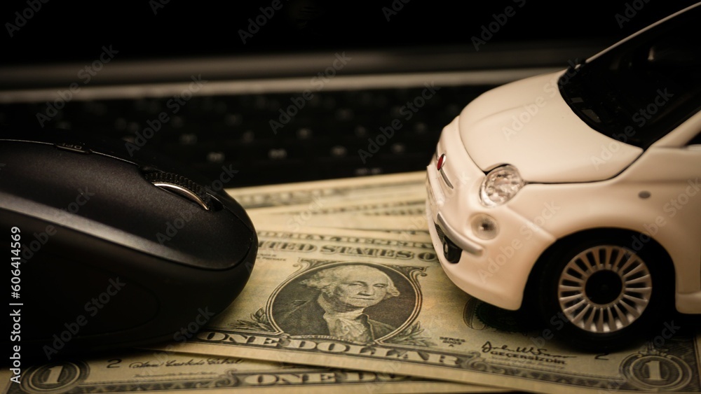 Obraz premium Car expenses concept with miniature toy car on and mouse on dollar bills