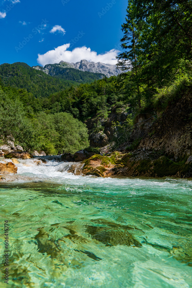 Amazing wild water in mala korita Soce valley, small pure clear turquoise flowing stream through stones gorge