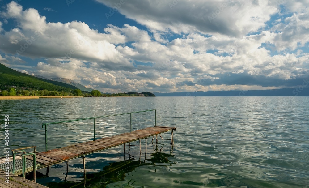 Wooden pier in the Lake Ohrid against a cloudy sky in North Macedonia