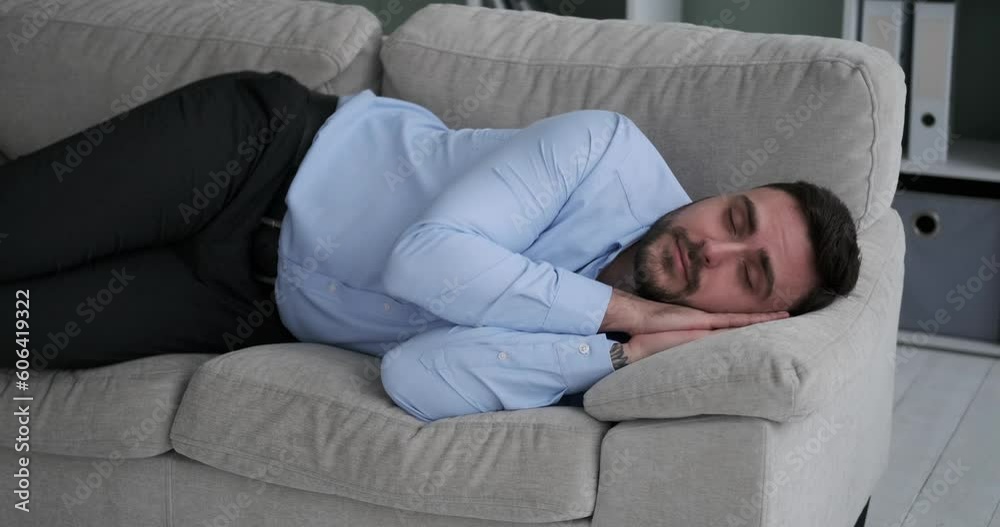 Stock video of a content and exhausted Caucasian office worker napping on a couch in their clothes. The person looks peaceful and happy as they rest and recharge. Stock video of a content and exhausted Caucasian office worker napping on a couch in their clothes. The person looks peaceful and happy as they rest and recharge.