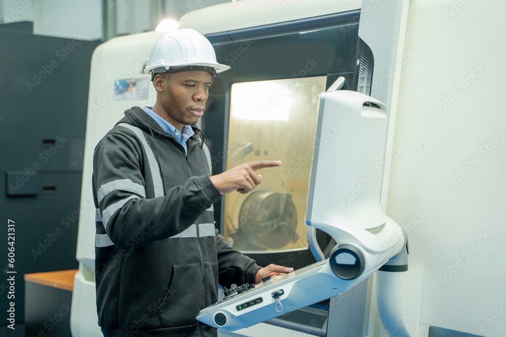 Engineer checking and operation controlling automated robot hand with CNC machine in factory,Technology, automation,Innovation and engineering concept. Engineer checking and operation controlling automated robot hand with CNC machine in factory,Technology, automation,Innovation and engineering concept.