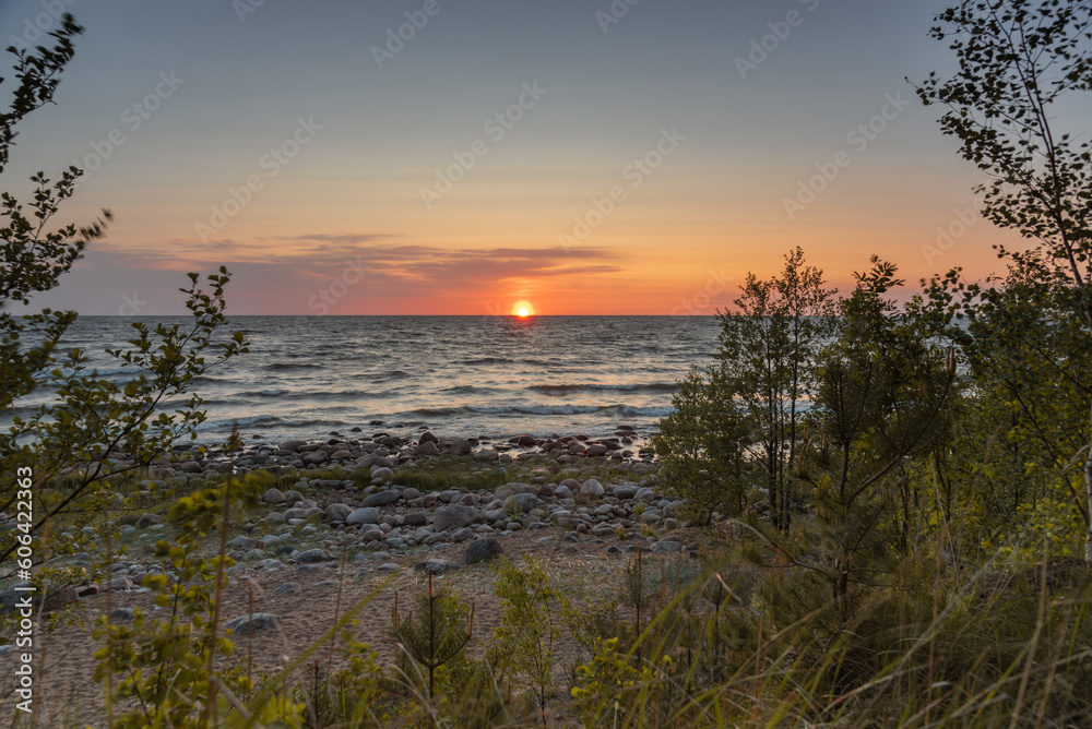 Sunset on the Baltic sea beach full of rocks at Vidzeme, Latvia.