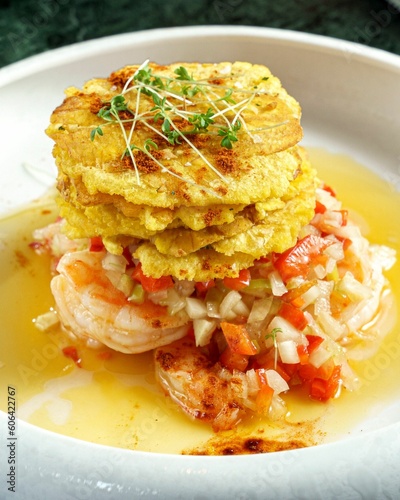 Vertical close-up of shrimp salpicon with fried plantain toston on a white plate photo