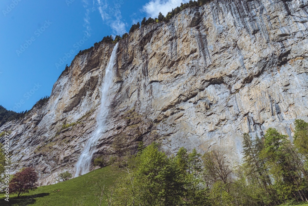 Waterfall flowing on a rocky mountain under blue sky