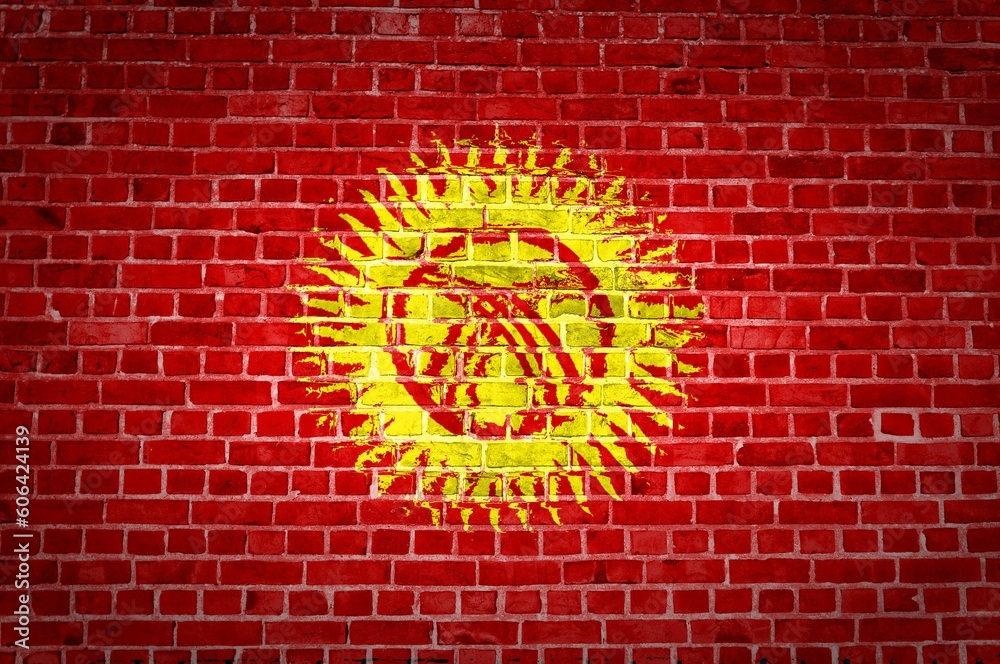 The Kyrgyzstan flag painted on a brick wall in an urban location The Kyrgyzstan flag painted on a brick wall in an urban location