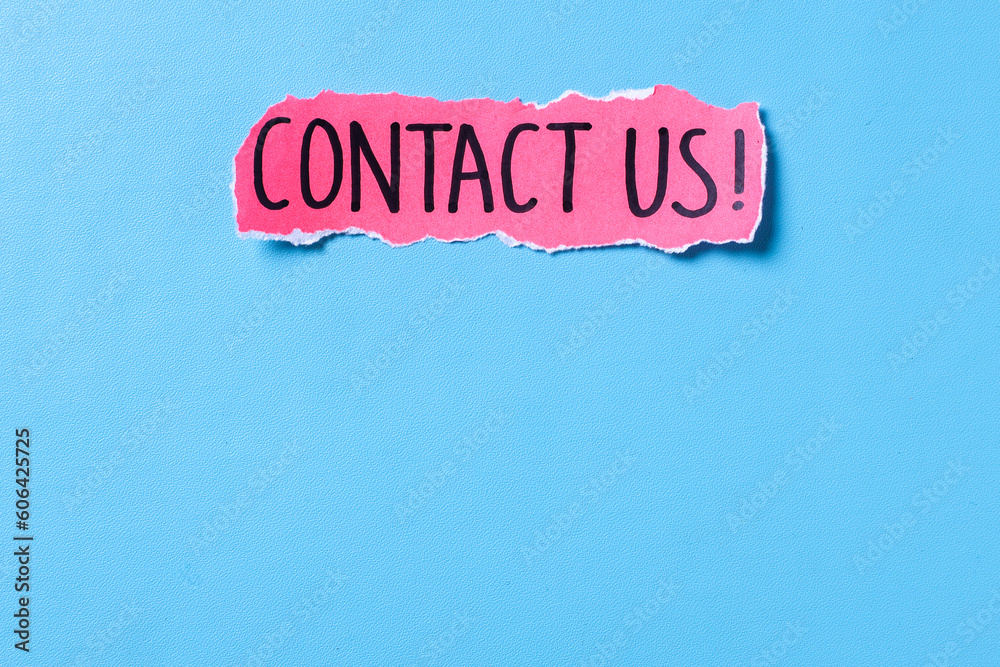 Words Contact Us written on torn paper isolated over blue background with copy space. Space fot text