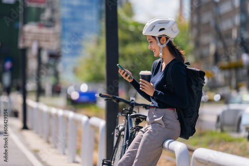 Asian woman bike to work In good weather, she rests on the way and drinks coffee.