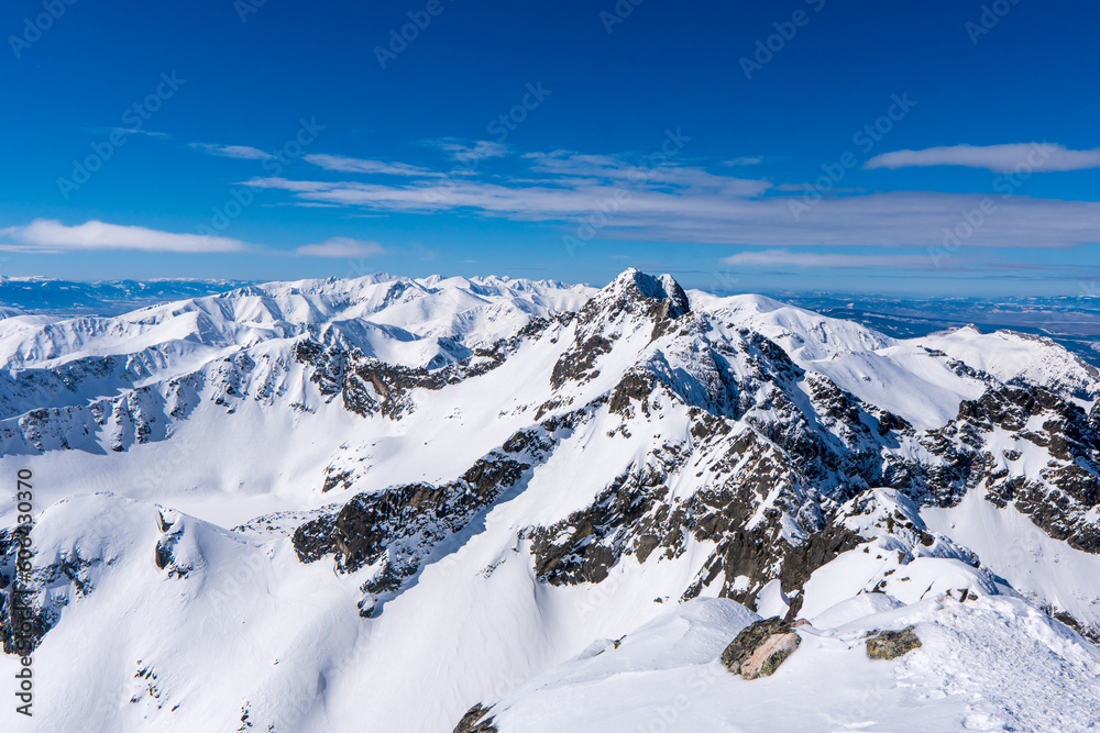 Beautiful winter scenery of Swinica and Beskid Peak from Kozi Wierch Peak in Tatras Mountains, famous place in Tatras with chalet. Poland. Tatra National Park
