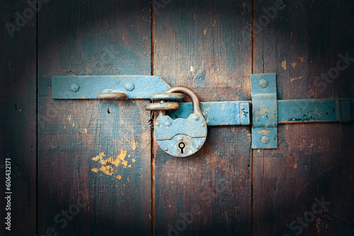 Old rusty padlock on a wooden door. Vintage camera effect on image