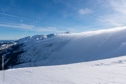 Black and white panorama of high snow-capped mountain peaks and beautiful sky with clouds at sun windy day. Caucasus Mountains in winter, region Slovakia, mount Baranec in West Tatras mountain in slo photo